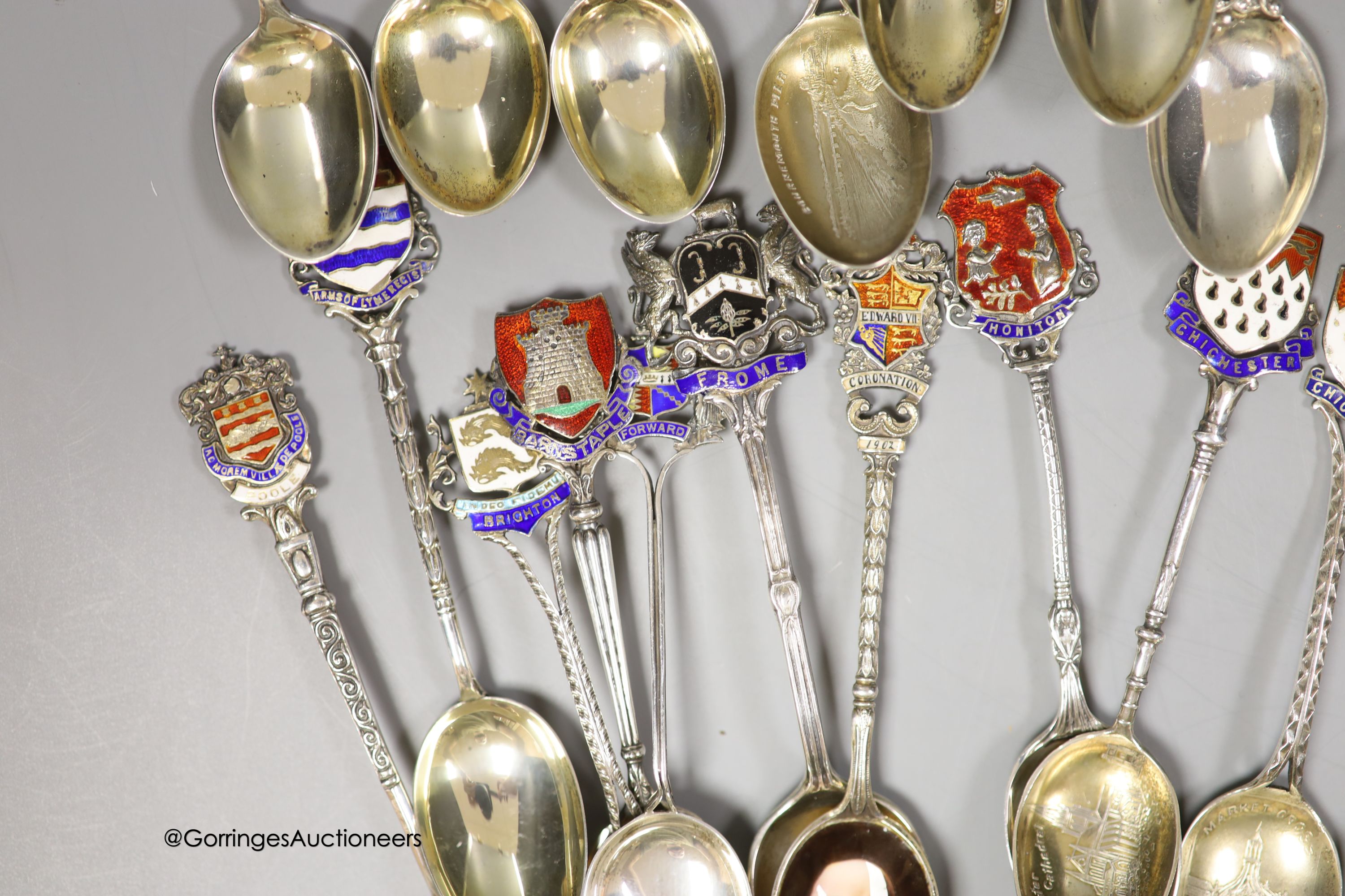 Twenty five assorted 20th century silver and enamel souvenir spoons, including Brighton, Bournemouth, Eastbourne, Chichester etc. and and Edward VII Coronation spoon, together with a similar white metal spoon, gross weig